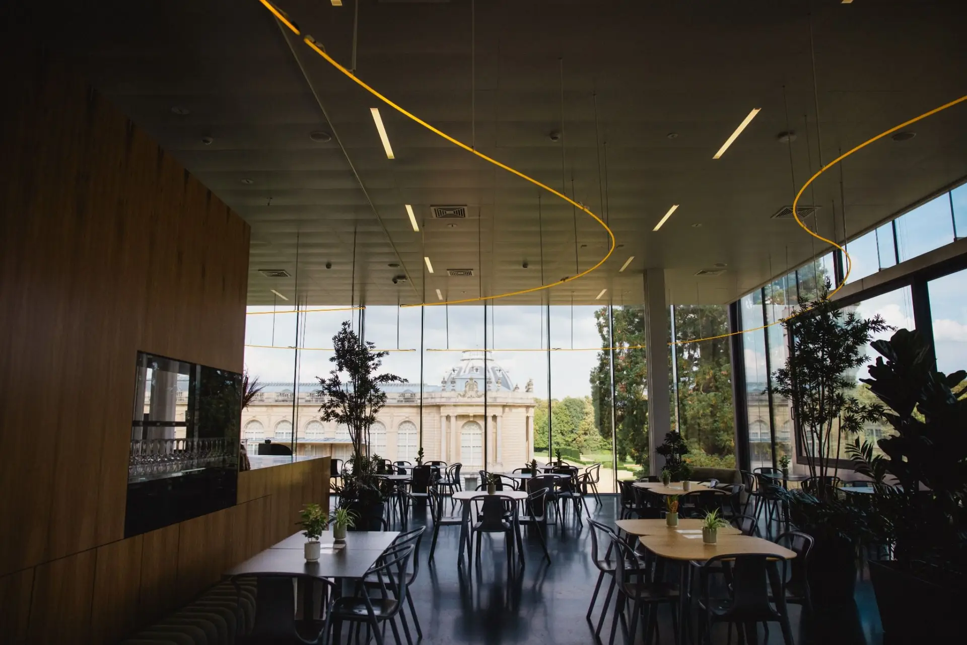Zonovergoten zaal van Africafé met houten tafels en hoge boogramen